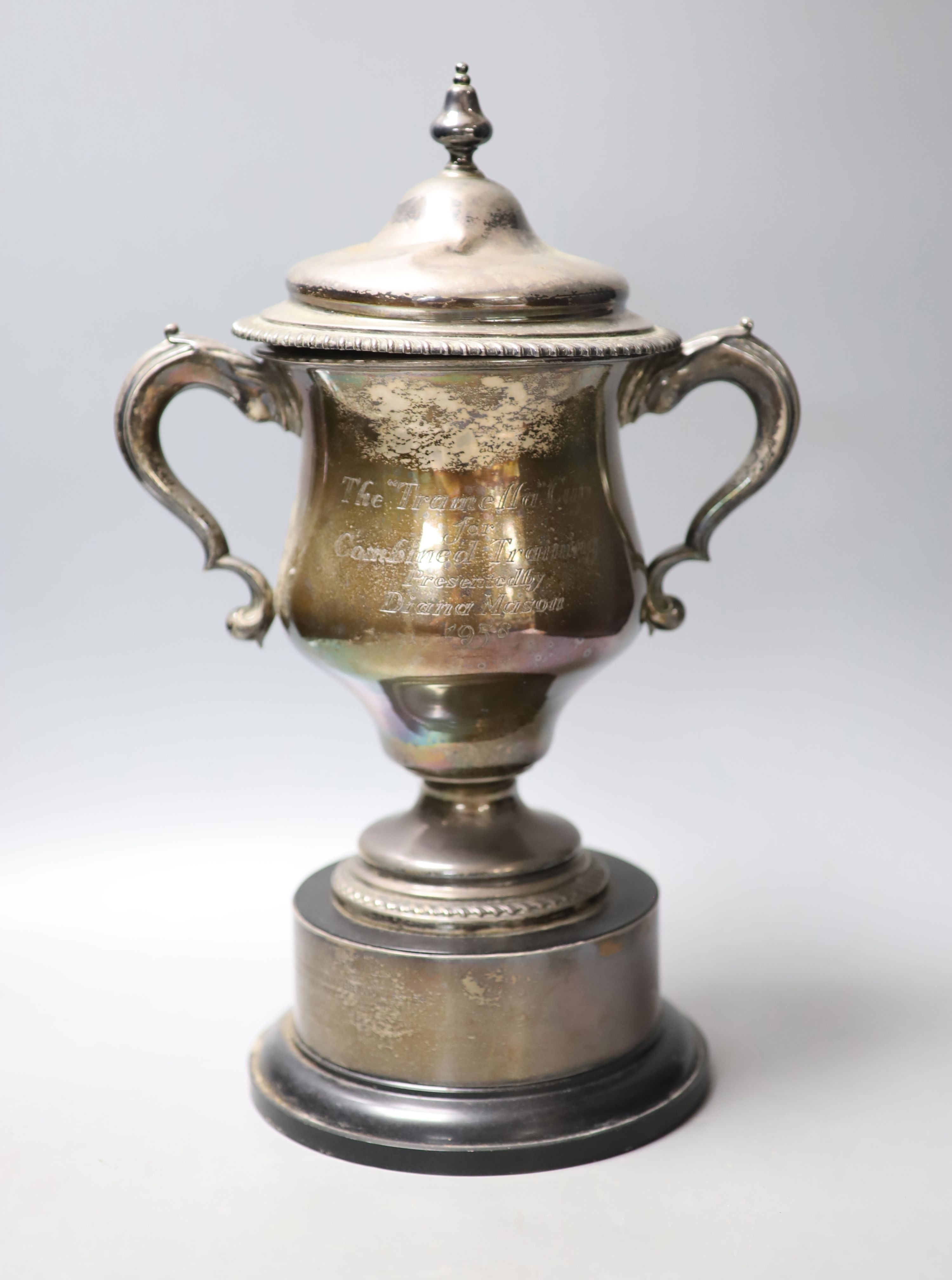 An Edwardian silver two handle presentation trophy cup and cover(a.f.) with later engraved inscription, Martin, Hall & Co, Sheffield, 1909, fixed to wooden socle, cup and cover height 30.4cm, cover 10.5oz.